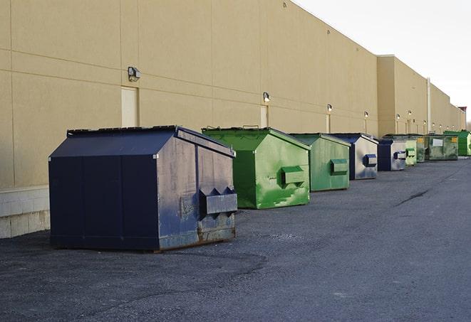 a construction worker disposing of debris into a dumpster in Bloomfield, NY